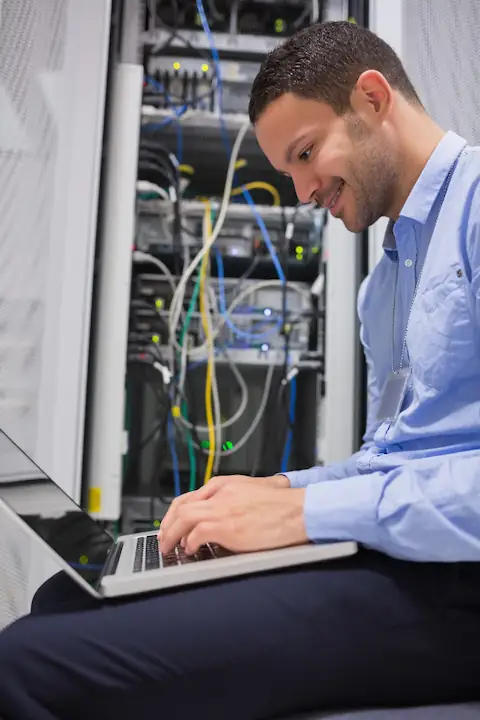 UKNode network engineer cabling a rack — the physical layer behind the AS215262 backbone.